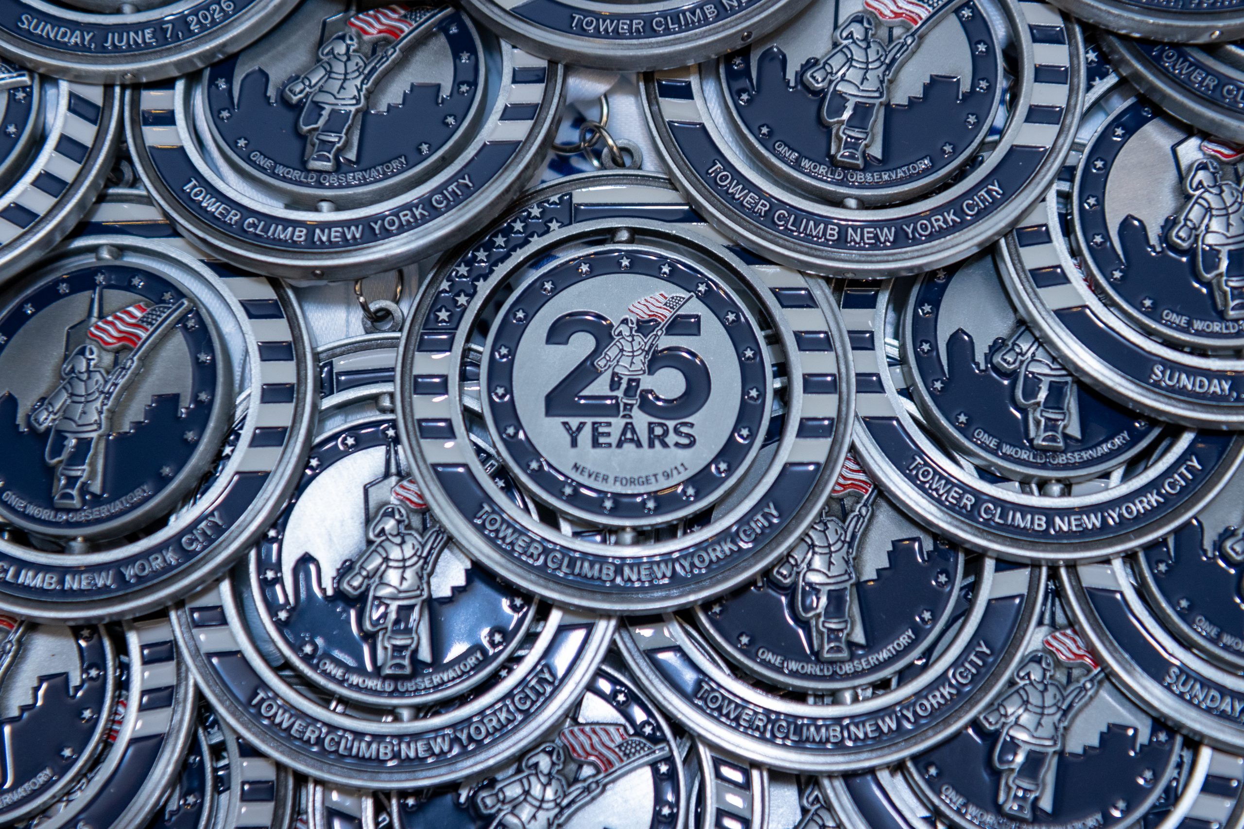 Stack of commemorative Tunnel to Towers Tower Climb NYC medals marking the 25th anniversary 9/11 remembrance event.